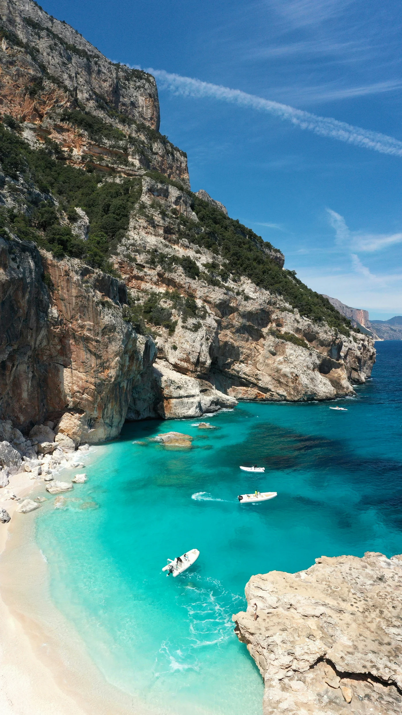 High limestone cliffs above the blue water of Cala dei Gabbiani, Sardinia